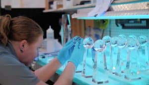 A production worker handling crystal awards